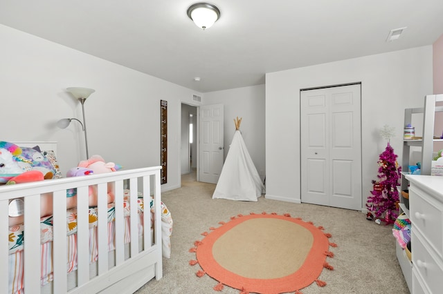 bedroom with visible vents, carpet, and a closet