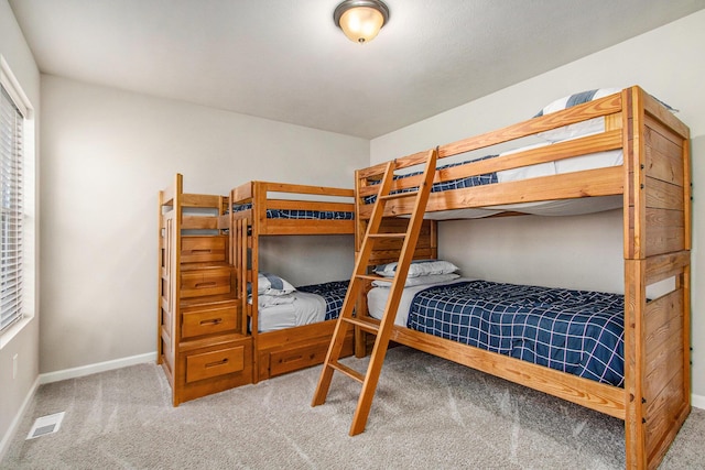 carpeted bedroom featuring visible vents and baseboards