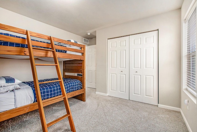 bedroom with a closet, baseboards, visible vents, and carpet floors