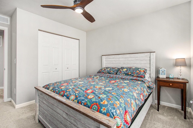 carpeted bedroom featuring a closet, baseboards, visible vents, and ceiling fan