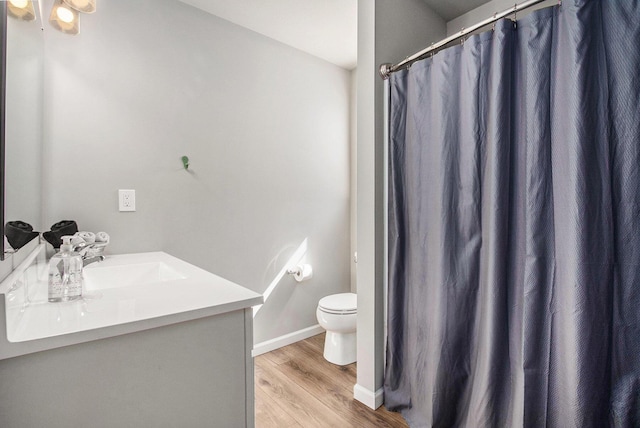 full bathroom featuring toilet, wood finished floors, a shower with shower curtain, baseboards, and vanity