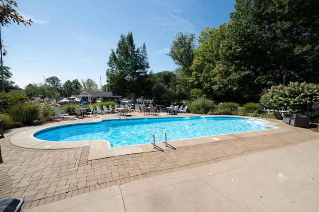 community pool with fence and a patio area