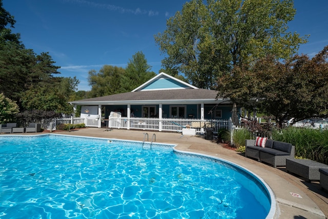 view of swimming pool featuring a patio area, a fenced in pool, and fence