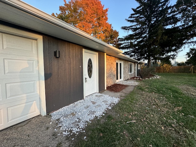 property entrance featuring a yard and stone siding