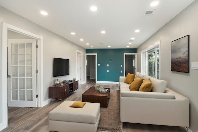 living room featuring wood finished floors, recessed lighting, visible vents, and baseboards