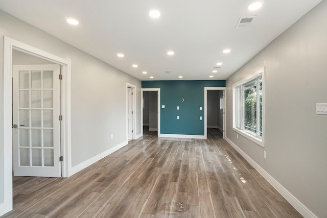 spare room featuring visible vents, recessed lighting, baseboards, and wood finished floors