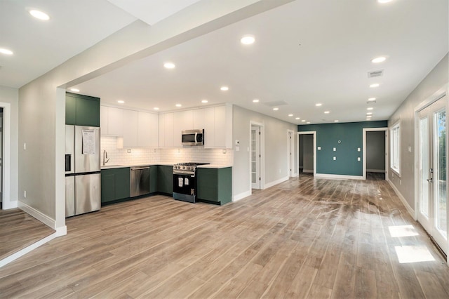 kitchen featuring visible vents, light countertops, decorative backsplash, stainless steel appliances, and a sink