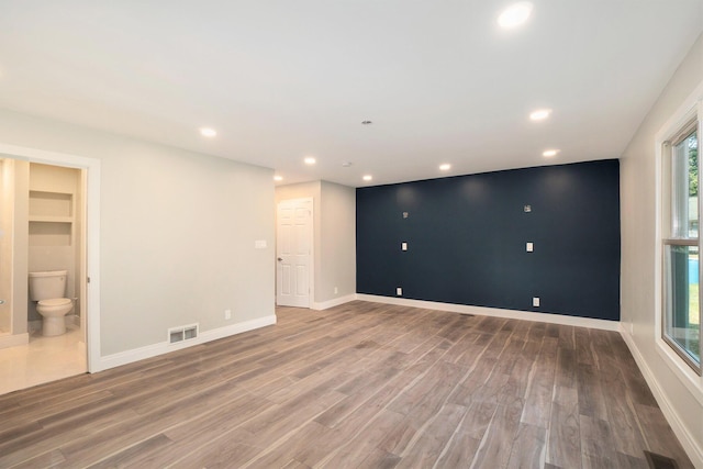 spare room with recessed lighting, visible vents, baseboards, and wood finished floors