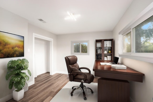 office area with visible vents, baseboards, and wood finished floors