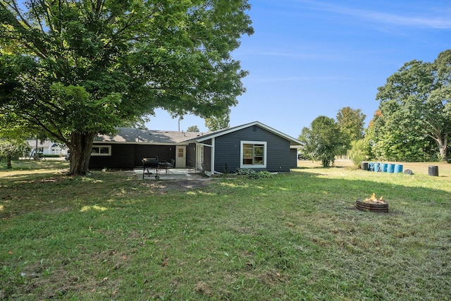 back of property with a patio area, a lawn, and an outdoor fire pit