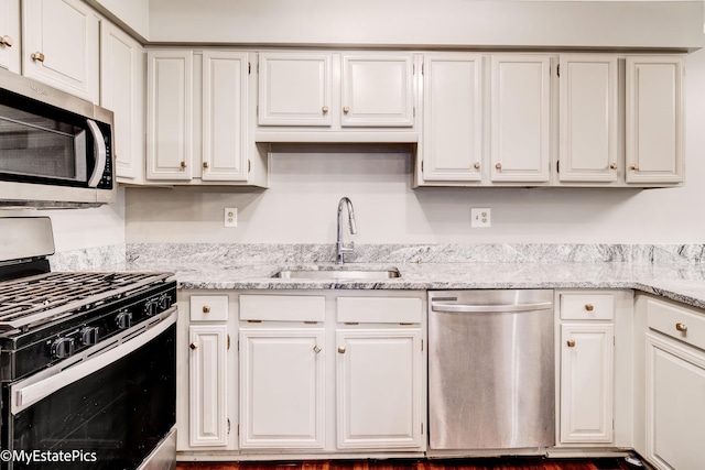 kitchen featuring white cabinets, stainless steel appliances, and a sink