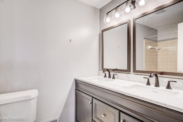 full bathroom with a sink, toilet, walk in shower, and double vanity