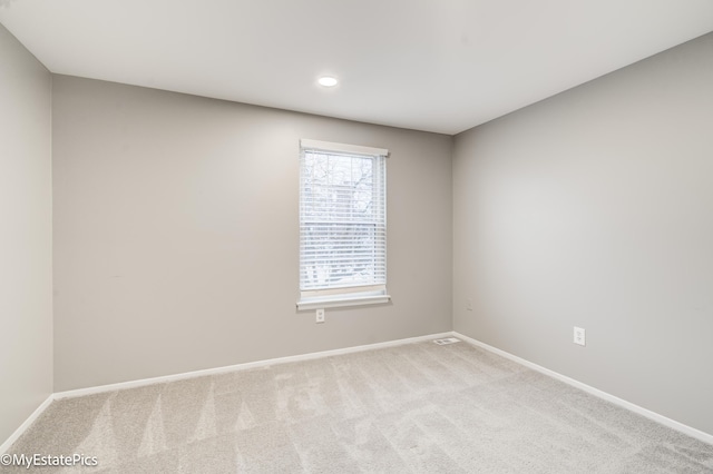 carpeted spare room featuring baseboards