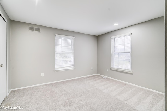 empty room with visible vents, baseboards, and carpet