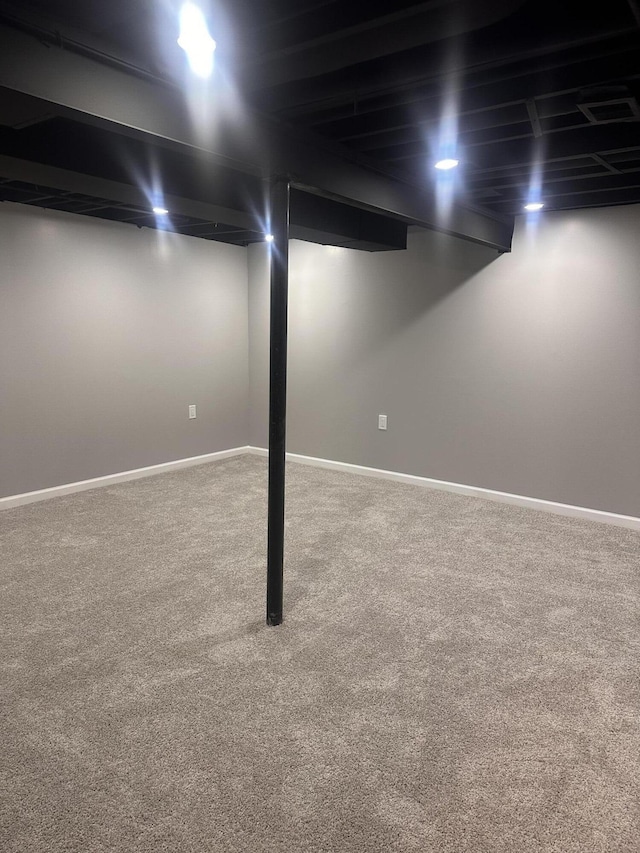 finished basement featuring baseboards and carpet floors