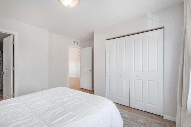 bedroom featuring a closet, visible vents, and light wood finished floors