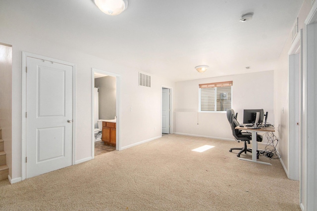 home office with baseboards, visible vents, and light carpet