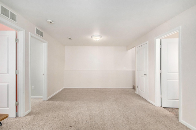 carpeted empty room featuring visible vents and baseboards