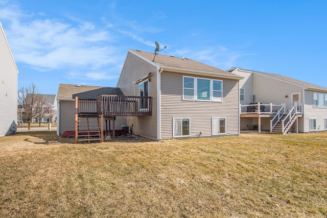 back of property with a lawn, stairs, and a deck