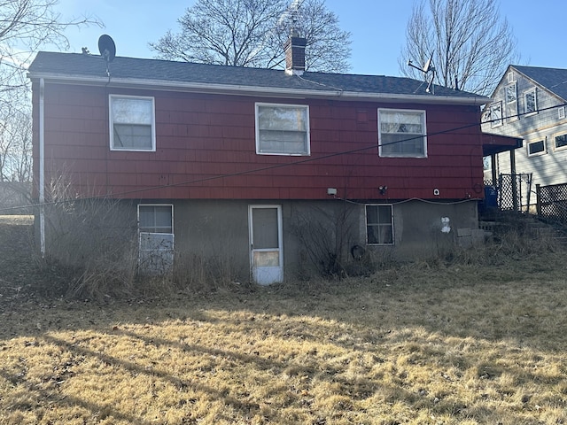 back of property with a lawn and a chimney