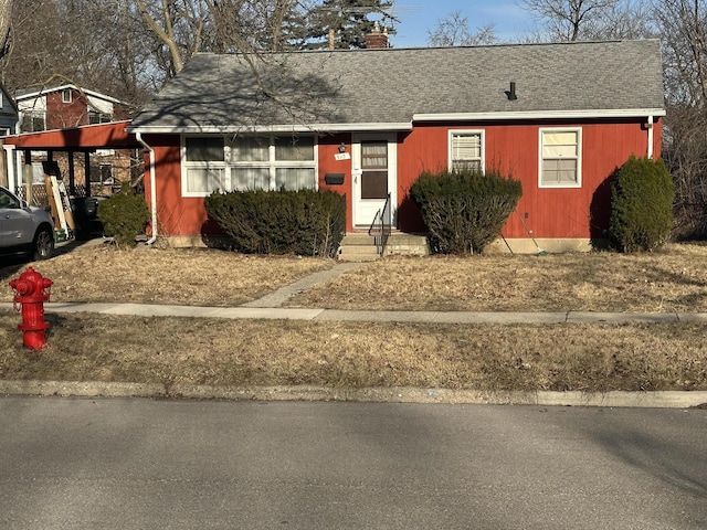 ranch-style home with entry steps and a shingled roof