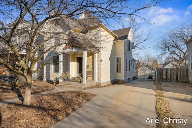 view of front of home featuring fence, driveway, and roof with shingles