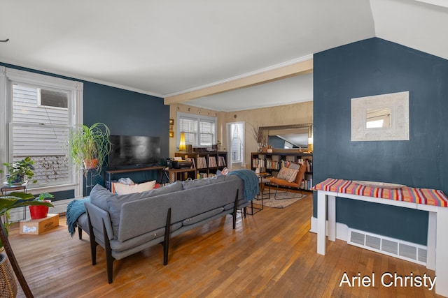 living area with visible vents, lofted ceiling, hardwood / wood-style floors, and crown molding