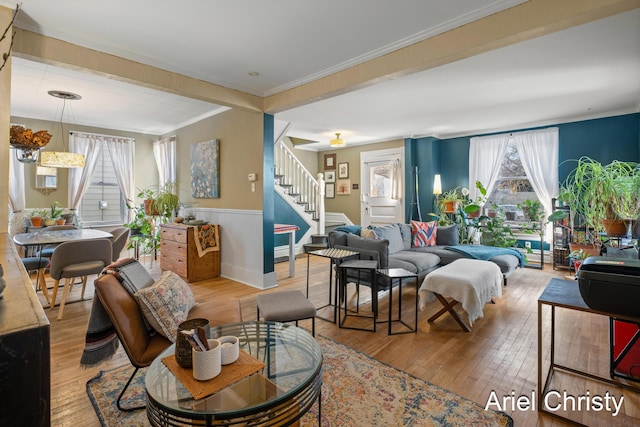 living room featuring stairway, a wainscoted wall, hardwood / wood-style floors, and crown molding