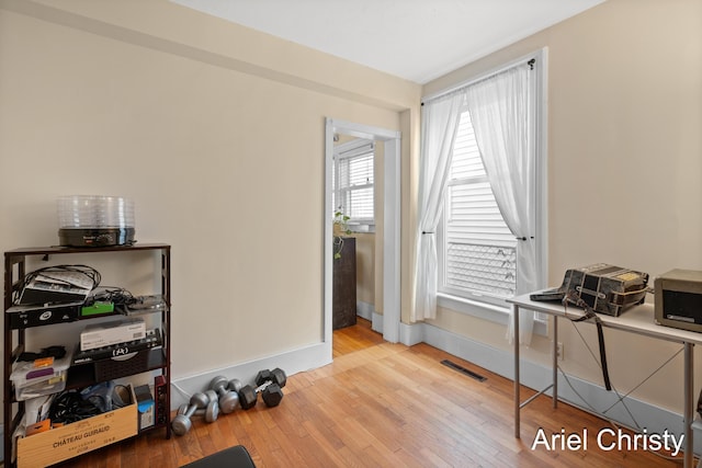 miscellaneous room featuring visible vents, baseboards, and hardwood / wood-style floors