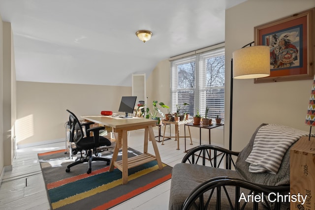 office space featuring vaulted ceiling, wood finished floors, and baseboards