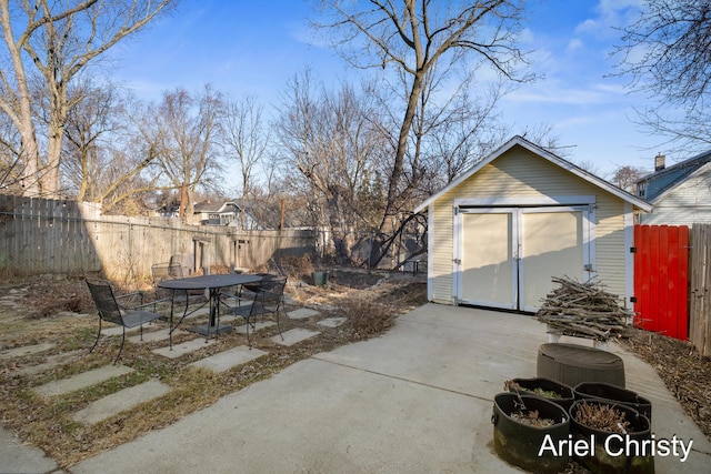 exterior space with a storage shed, an outbuilding, a fenced backyard, and a patio