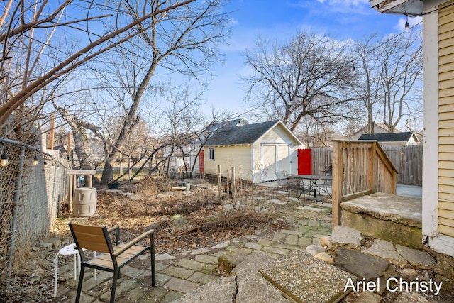 view of yard featuring an outdoor structure, a fenced backyard, and a patio area