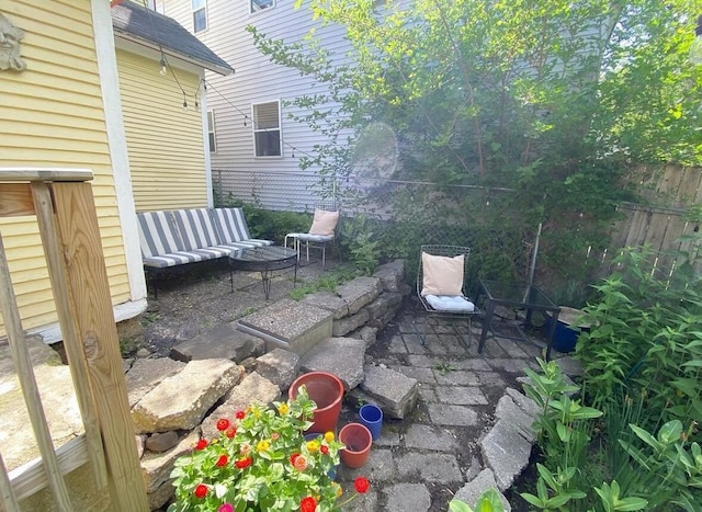 view of patio with an outdoor living space and fence