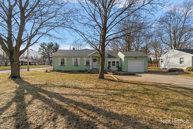 ranch-style home with driveway, a front yard, and an attached garage