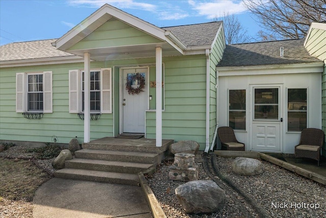 doorway to property featuring a shingled roof