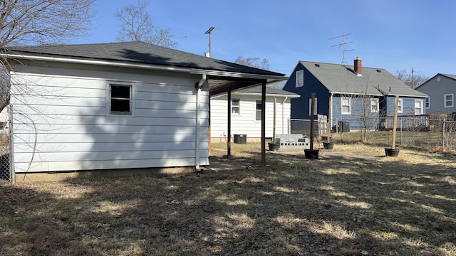 back of property with central AC unit, fence, and a shingled roof