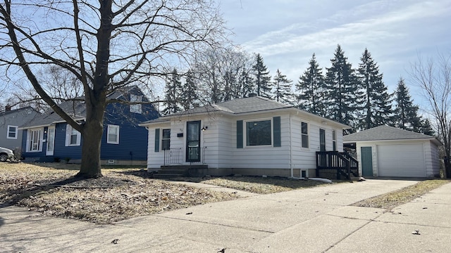 view of front of property featuring driveway, a shingled roof, a detached garage, and an outdoor structure