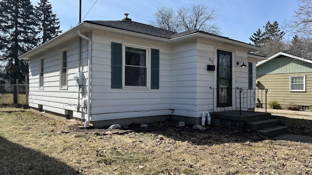 bungalow featuring roof with shingles and fence