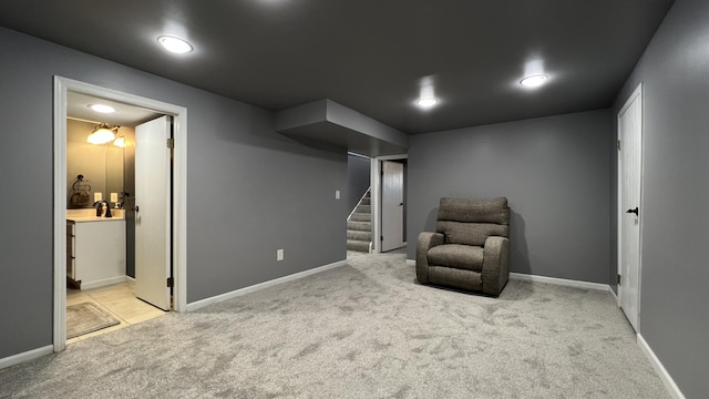 sitting room featuring stairway, light carpet, and baseboards