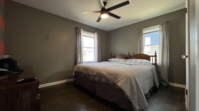 bedroom with dark wood-style floors, baseboards, and ceiling fan