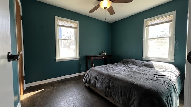 bedroom with multiple windows, a ceiling fan, baseboards, and wood finished floors