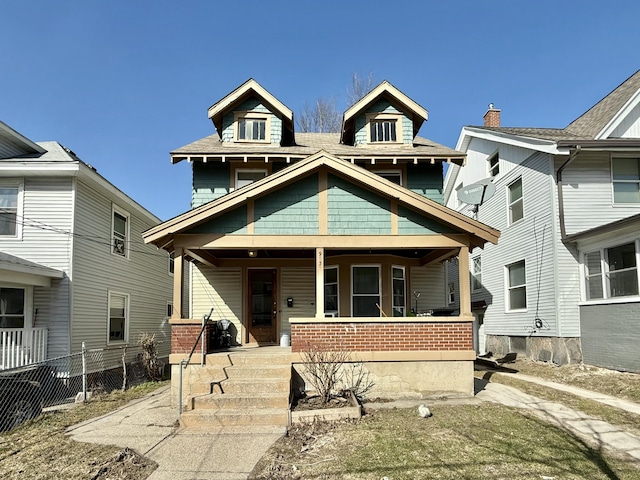 traditional style home with a porch and fence