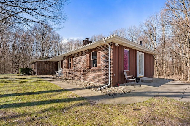 61914 M-51, Niles, MI 49120 - view of side of property with brick siding, a lawn, board and batten siding, and a chimney