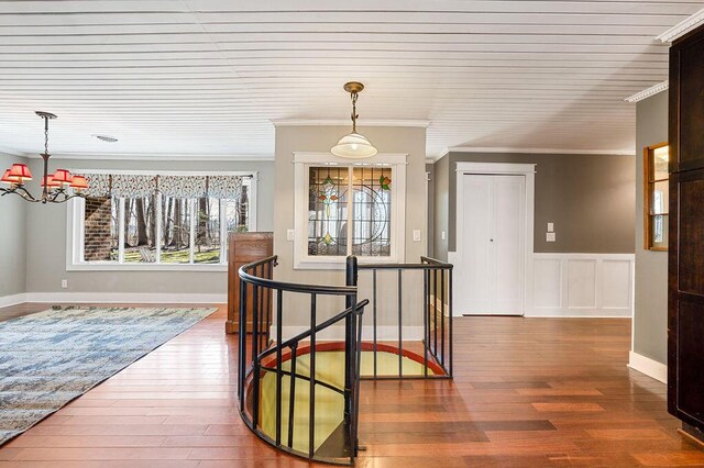 61914 M-51, Niles, MI 49120 - corridor featuring a wainscoted wall, an upstairs landing, a notable chandelier, ornamental molding, and wood finished floors