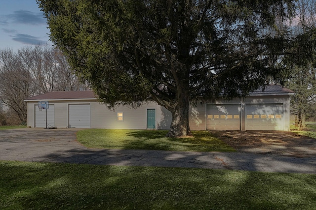 view of front facade with a garage, metal roof, and a front lawn