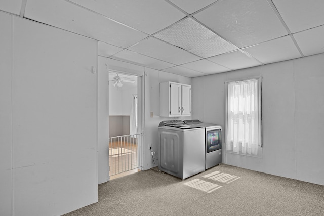clothes washing area featuring washer and dryer, cabinet space, and light colored carpet
