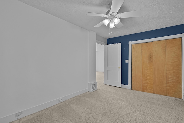 unfurnished bedroom featuring baseboards, visible vents, a textured ceiling, and carpet