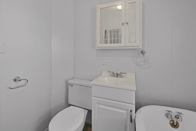full bathroom with a freestanding tub, toilet, and vanity