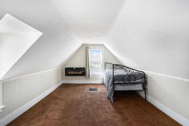 unfurnished bedroom with visible vents, lofted ceiling, and carpet floors