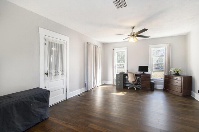 home office with visible vents, ceiling fan, baseboards, and wood finished floors